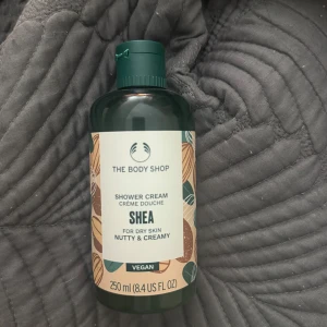 The Body Shop Shea Shower Cream 250ml - The Body Shop Shea Shower Cream är en vegansk duschkräm med krämig och nötig doft, perfekt för torr hud. Kommer i en mörkgrön plastflaska. Innehåller 250 ml, aldrig blivit använd då den ej passar min hudtyp, säljer för 80 kr. 