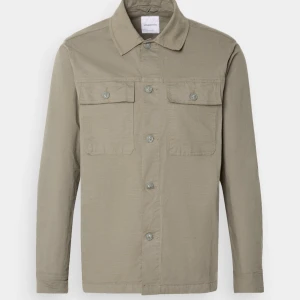 Olivgrön overshirt från Lindbergh S - Säljer en helt ny overshirt som jag köpte och använde en gång för jag fick en ny så har bara använt den 1 gång, den är lite större i storleken men den e S men kan nog passa M också, ny pris är 899kr 