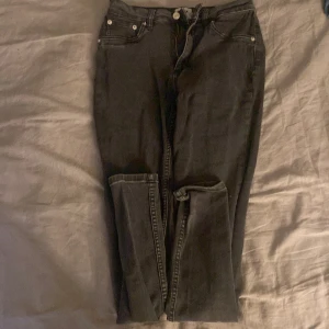 Svarta jeansbyxor - Snygga svarta jeansbyxor med femficksdesign och knappgylf. Perfekta för en stilren look. De har en klassisk passform och är tillverkade i ett slitstarkt material.