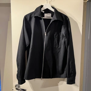 Navy over shirt  från Selected Homme - Snygg navy jacka från Selected Homme med dragkedja framtill och en bröstficka. Jackan har en klassisk krage och långa ärmar, perfekt för en stilren look.