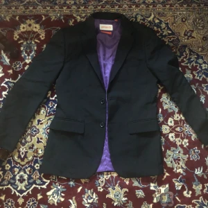 Kavaj - Svart kavaj med lila detaljer, passar m/s.  Finns en slips till om man vill ha också