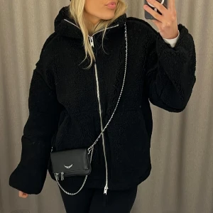 Svart teddyjacka med dragkedja - Mysig svart teddyjacka med dragkedja framtill. Jackan har en hög krage och två stora fickor.💖