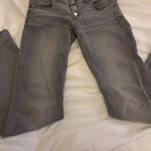 Grå jeans med knappar - Super fina gråa jeans från gina tricot. Använda fåtal gånger, är lite nertrampade men inget som syns. Det är också en liten maska på låret som man kan se på första bilden men värkligen inget man tänker på. Pris kan diskuteras vid snabbt köp🫶🏻