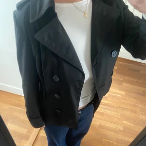 Kort trenchcoat - Säljer denna supersnygga svarta korta trenchcoaten! 