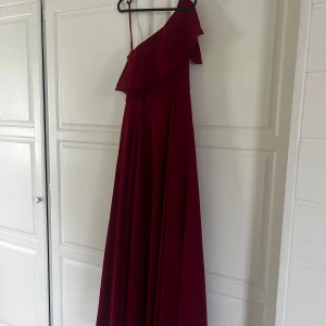 Balklänning (Röd) - Säljer denna helt nya röda balklänning ifrån flormiss. Jag valde att behålla en likadan klänning fast i rosa och därav är den ny! Storlek: 34 och väldigt fin passform💓