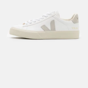 Vita sneakers från Veja - Snygga vita sneakers från Veja med beige detaljer och snörning. Skorna har en klassisk design med märkets logga på sidan och hälen. Perfekta för en stilren look.