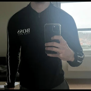 Hugo Boss tröja - Zip tröja från Hugo Boss. Skicket på tröjan är mycket god, tvättad enligt anvisningar och säljs pga för lite användning.