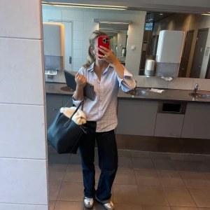 Randig skjorta i blått och vitt - Snygg och klassisk randig skjorta i blått och vitt. Skjortan har en normal passform och långa ärmar, perfekt för en stilren look. Den är tillverkad i ett bekvämt material och har knappar framtill.