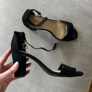 Svarta klackskor med öppen tå - Bred klack, lätta att gå i. Perfekta till vilken outfit som helst. Ca 8cm klack.  Säljer pga har för många så dessa kommer sällan till användning