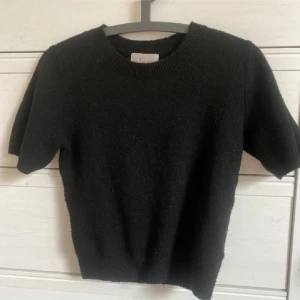 Svart kortärmad tröja från H&M - Säljer en stilren svart tröja från H&M. Den är kortärmad och har en rund halsringning. Perfekt för en enkel och klassisk look. Passar bra till både jeans och kjol.