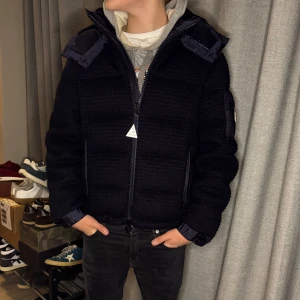 Mörkblå pufferjacka från Moncler - Tja! Säljer denna snygga mörkblå pufferjacka från Moncler. Jackan har en quiltad design med en huva och dragkedja framtill. Perfekt för kyliga dagar och ger en stilren look. Moncler-logga på ärmen ger en exklusiv touch. Använd 1 gång, kvitto finns, givetvis äkta! Vid fundering är det endast att höra av sig!