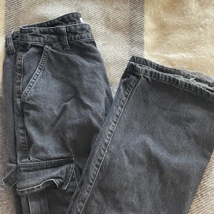 Svarta cargobyxor från NA-KD - Snygga svarta cargobyxor från NA-KD med  praktiska fickor på sidorna. Wide legged, baggy. Bra kvalite utom lite healbite. 