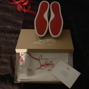 Vita och rosa sneakers från Christian Louboutin (LIMITERAD) - Snygga vita sneakers med rosa detaljer från Christian Louboutin. Skorna har rosa snörning och den ikoniska röda sulan. Perfekta för att ge din outfit en lyxig touch. De är limiterade samt aldrig använts. Pris kan diskuteras 