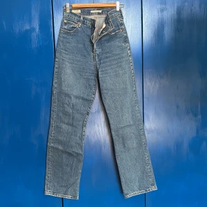 Levi's Premium Ribcage Straight Ankle Jeans - Snygga Levi's Premium Ribcage Straight Ankle jeans i klassisk blå denim. Dessa jeans har en hög midja och rak passform som ger en tidlös look. Bra skick och sköna! Har varit ett par favoriter💘