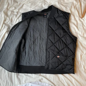 Svart quiltad väst från Dickies - Säljer en svart quiltad väst från Dickies i storlek XL. Bra för lager i lite kallare väder