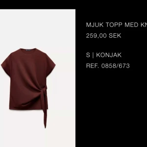 Mjuk topp med knyt - Säljer en mjuk topp i vinröd med knyt i sidan. Toppen har korta ärmar och en rund halsringning. Perfekt för en stilren look. Aldrig använd!