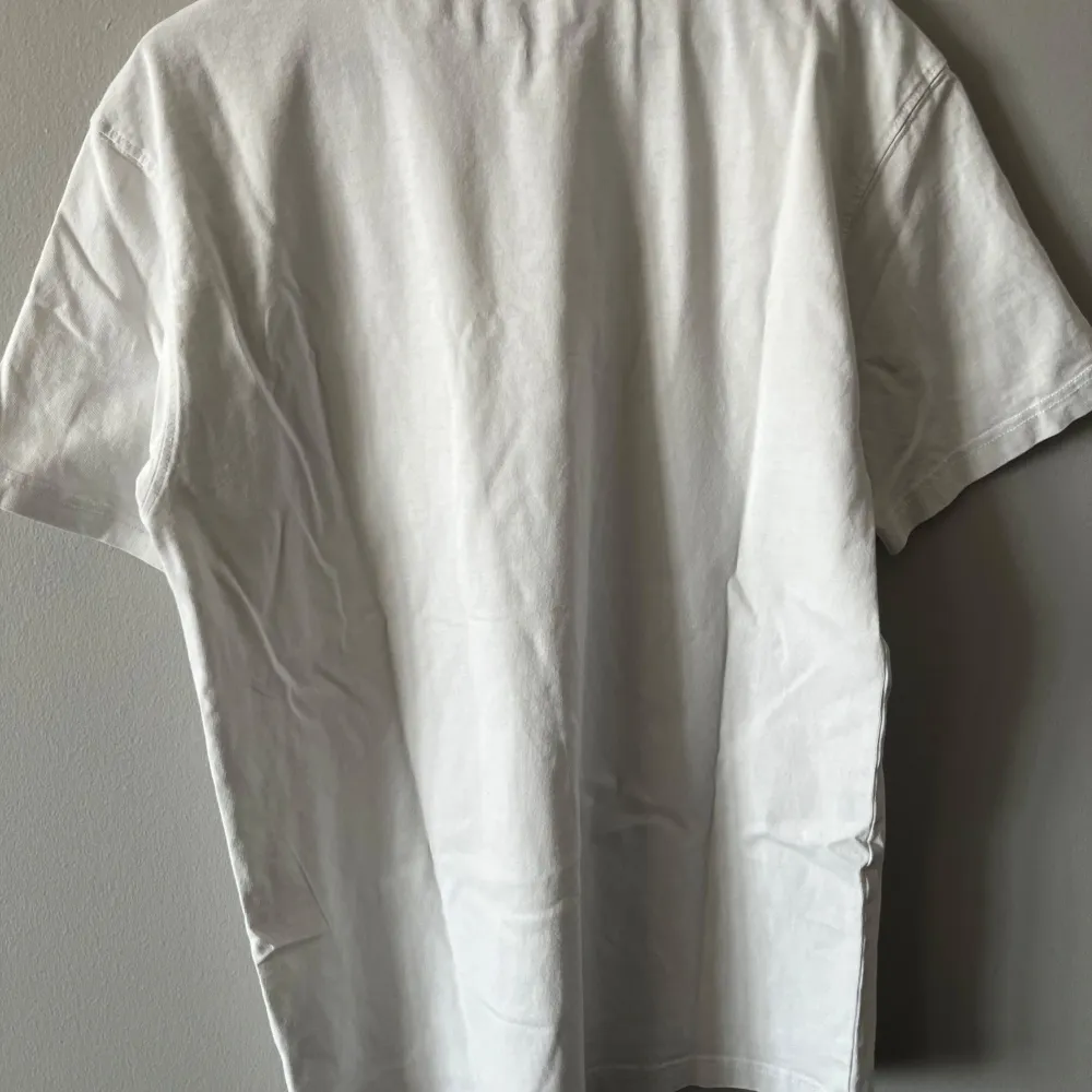 Säljer en klassisk vit t-shirt från Dickies i storlek medium. T-shirten har en bröstficka med en liten Dickies-logga. Perfekt för en avslappnad stil.. T-paidat.