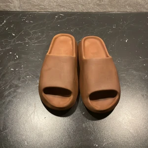 Yeezy slides  - Bruna storlek 45.5 yeezy slides, använda men kan lätt bli rengörda 