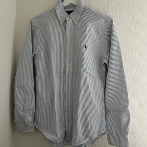 Randig skjorta från Ralph Lauren - Snygg randig skjorta från Ralph Lauren i blått och vitt. Skjortan har en slim fit passform, storlek S och i mycket bra skick.