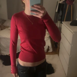 Fin stickad tröja  - Snygg röd fin stickad tröja med gulddetaljer som man ser på bilden,från Lindex och  aldrig använd så fin!