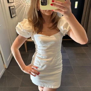 Vit kort klänning med puffärmar - Säljer denna jättefina vita klänning med puffärmar och öppen i ryggen från Asos! Perfekt till studenten💓endast använd en gång! Nypris 599kr