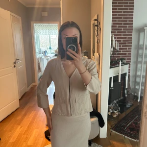 Beige kavaj från Zara - Snygg beige kavaj/ kofta  med trekvartsärmar. Fickor framtill och en diskret knäppning. Perfekt för en chic och avslappnad look.