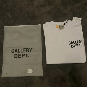 Vit t-shirt från Gallery Dept. - Säljer en stilren vit t-shirt från Gallery Dept. med tryck på både fram- och baksidan. Jag säljer pågrund av T-shirten är väldigt oversized som inte är exakt min still som gillar lite mer slim T-shirts.