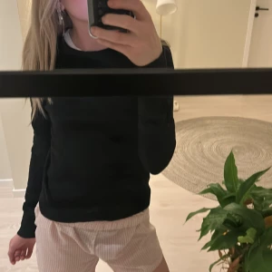 Svart tröja från Gina Tricot - Säljer en stilren svart tröja från Gina Tricot. Tröjan har en klassisk design med långa ärmar och rund halsringning. Perfekt för en enkel och snygg look. Passar bra till både jeans och kjol.