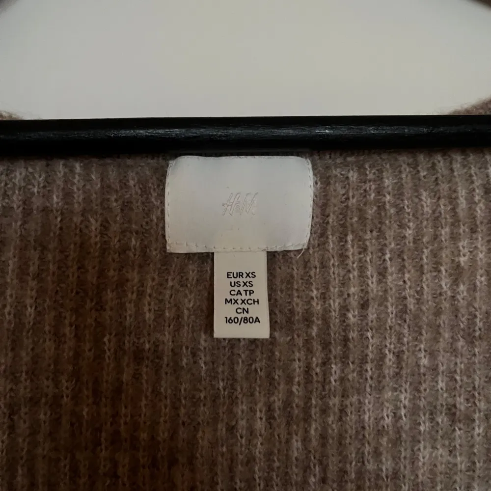 Säljer en mysig beige stickad klänning från H&M. Klänningen har en v-ringad design och långa ärmar, perfekt för kyligare dagar. Den är i en smickrande tight passform som framhäver figuren. Perfekt för höst och vinter!. Mekot.