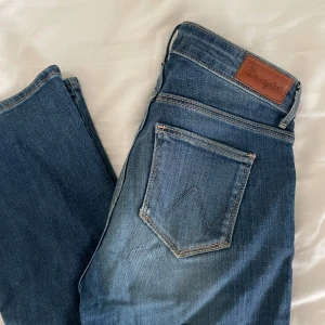 Blåa jeans från wrangler - Säljer ett par skit snygga bootcut lågmidjade jeans från wrangler då de tyvärr inte passar mig längre! Innerbenslängd: 83cm, midjemått: 35cm rakt över!❤️Storlek: W25 L32