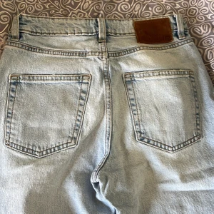 Ljusblå jeans från 157 - Säljer ett par ljusblå jeans från 157 i storlek XS. De har en klassisk femficksdesign med knappgylf och en läderpatch baktill.