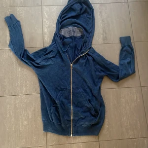 Blå hoodie från Jacob Cohen - Säljer en snygg blå hoodie från Jacob Cohen, tillverkad i Italien. Den har en dragkedja framtill och en bekväm passform med långa ärmar. Perfekt för en avslappnad stil. Model 179 och 65 kg