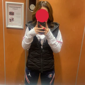 Svart quiltad väst från Zara - Säljer en svart quiltad väst från Zara med dragkedja. Perfekt för lager-på-lager under kyligare dagar. Västen har en stilren design och är lätt att matcha med olika outfits. Den är har använts mycket ena fickan dragkedjan är lite sönder så de går bara att dra upp halva fickan.