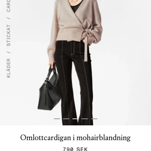 Mörkblå omlottcardigan - Säljer en snygg mörkblå omlottcardigan med knytning i sidan. Den marin blå färgen säljs inte längre så passa på! 