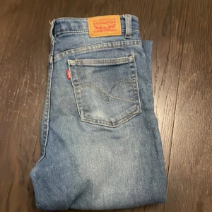 Levi's Ribcage Straight Ankle Jeans - Snygga ljusblå Levi's Ribcage Straight Ankle jeans med en klassisk femficksdesign. De har en hög midja och raka ben som slutar vid ankeln. Perfekta för en avslappnad stil. Dm för frågor! Priset är inte spikat!
