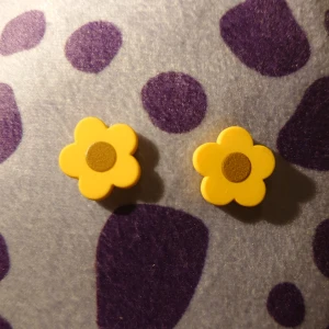 Gula blomformade örhängen trä - Söta örhängen i form av gula blommor med en brun mitt gjorda av trä. Perfekta för att lägga till en färgglad touch till din outfit. Passar bra till både vardag och speciella tillfällen. De är handgjorda (inte av mig). Inte använda.