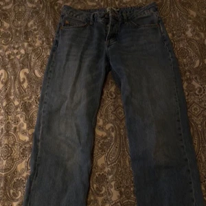 Blå ICON  jeans - Säljer ett par klassiska blå ICON  jeans. De har en rak passform och är tillverkade i slitstarkt denim. Perfekta för en avslappnad stil. Jeansens ikoniska design gör dem tidlösa och lätta att matcha med olika outfits.