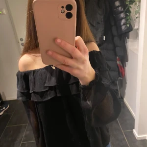 Svart offshoulder topp från Gina Tricot - Säljer en jätte fin  svart offshoulder topp från Gina Tricot. Toppen har långa ärmar och volangdetaljer.💖