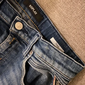 Blå jeans från Replay - Snygga blå jeans från Replay med klassisk femficksdesign och knappgylf. De har en lätt tvättad look och märkesdetaljer på bakfickan. Perfekta för en avslappnad stil.