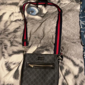 Gucci Väska (Axelarmväska) - Tjena! Säljer min Gucci axelarmväska. Enligt källor så är väskan äkta, men ifall du har funderingar och söker bilder för att identifiera det, så kan du bara fråga! Skicket är i god form. Startar med ett start pris på 1199kr, fast pris går att diskutera vid snabb affär.