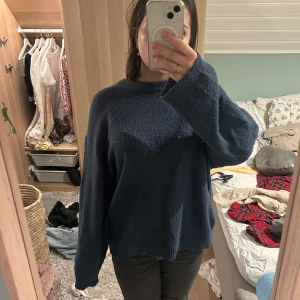 Mörkblå stickad tröja - Säljer en mysig mörkblå stickad tröja med normal passform. Tröjan har långa ärmar och en rund halsringning, perfekt för kyligare dagar. Passar bra till både jeans och kjol.