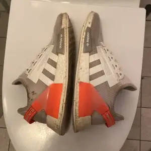 Säljer ett par Adidas NMD sneakers i beige med vita ränder och orange/rosa detaljer på hälen. Skorna har en klassisk design med snörning och en bekväm sula. Perfekta för en avslappnad stil. Jag säljer dom här skorna för att jag har inte tid och ork för att rengöra dom darför säljer jag dom. Dom är i bra skick förutom att dom ör lite smutsiga med det går lätt att rengöra. Jag fraktar samma dag som de köps. 
