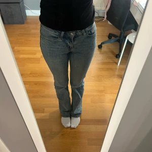 blåa lågmidjade jeans - säljer ett par blå lågmidjade jeans med normal passform. de har en femficksdesign och knäppning med dragkedja. storlek 32, bra längd för mig som är ca 160, lite slitningar längst ner💕