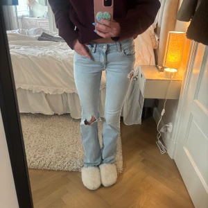 Lågmidjade bootcut jeans med hål  - Super snygga ljusblåa lågmidjade jeans med hål, inga defekter, är 170cm lång för referens. Storlek Xs full lenght. 