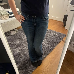 Blå jeans från American Eagle - Säljer ett par snygga blå jeans från American Eagle med Next Level Stretch för extra komfort. De har en klassisk femficksdesign och en låg midja. 