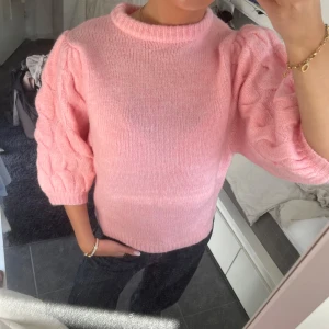 Rosa stickad tröja med puffärmar - Säljer en söt rosa stickad tröja med puffiga trekvartsärmar. Tröjan har en rund halsringning och en mjuk, bekväm passform. Perfekt nu till våren men även till sommar och höst🥰🥰