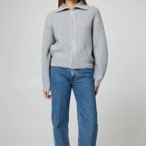 Grå ribbad kofta med dragkedja - Säljer en stilren grå ribbad kofta med dragkedja och krage. Perfekt för kyligare dagar och lätt att matcha med olika outfits. Koftan har långa ärmar och en bekväm passform.