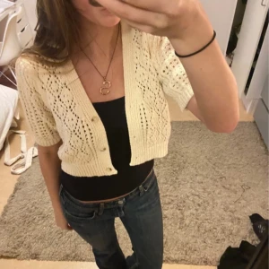 Beige stickad bolero - Säljer en söt beige stickad kofta med korta ärmar och knappar framtill. 