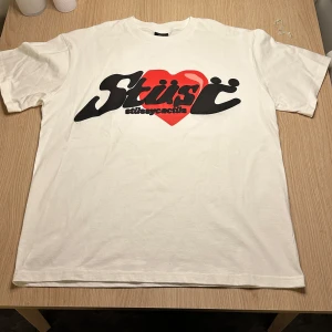 Stüssy x CPFM T-shirt - Säljer en snygg vit t-shirt frän Stüssy i samarbete med CPFM (cactus plant flee market). Den är kortarmad och i bomull med en boxy fit. Sallsynt troja och i super bra skicka. Kontakta mig vid intresse eller prutning. Stussy x CPFM