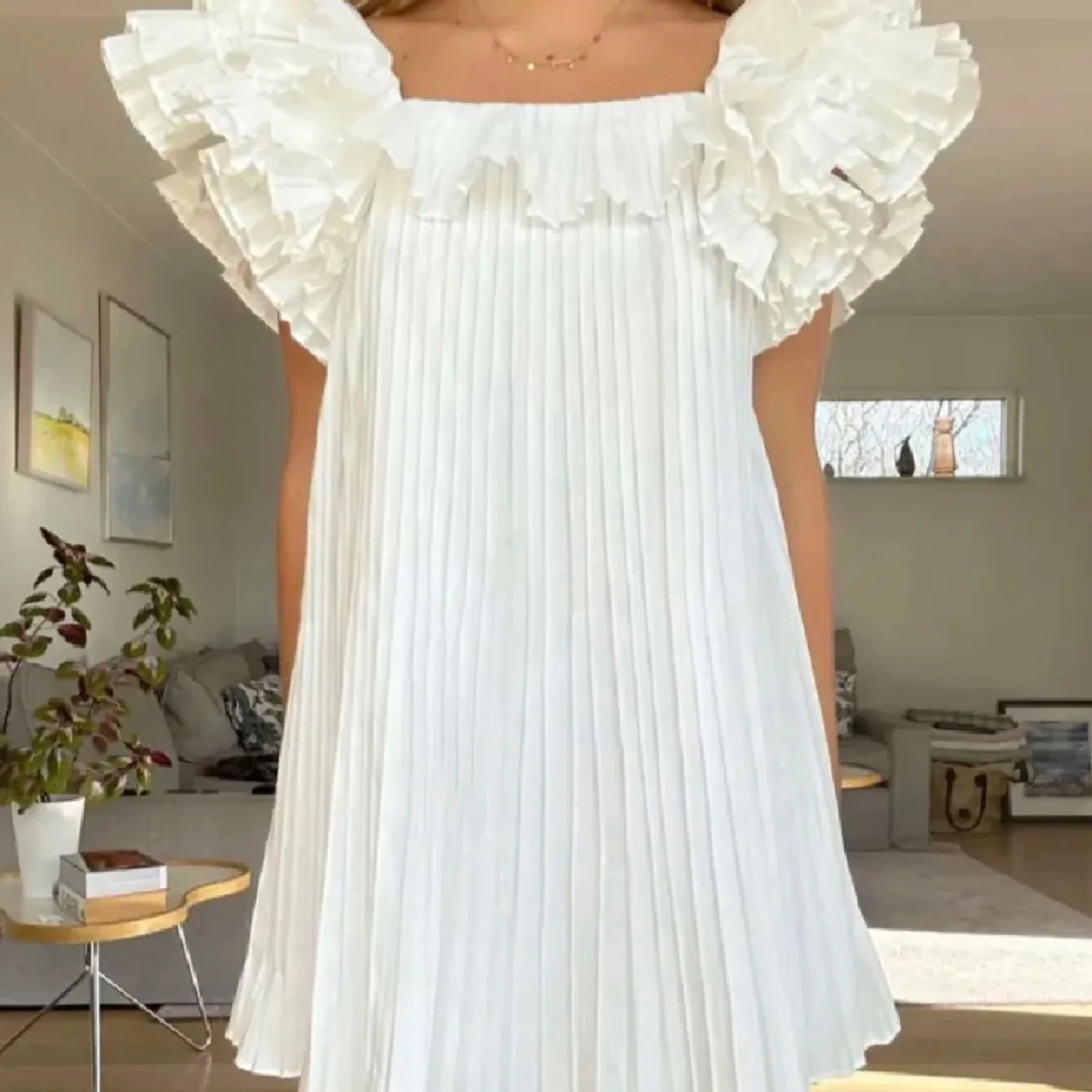 Vit plisserad klänning med volang